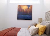 Thumbnail 22 of 36 - Bedroom with colorful artwork and decorative pillows at 68 Beale Apartments, Quincy, MA